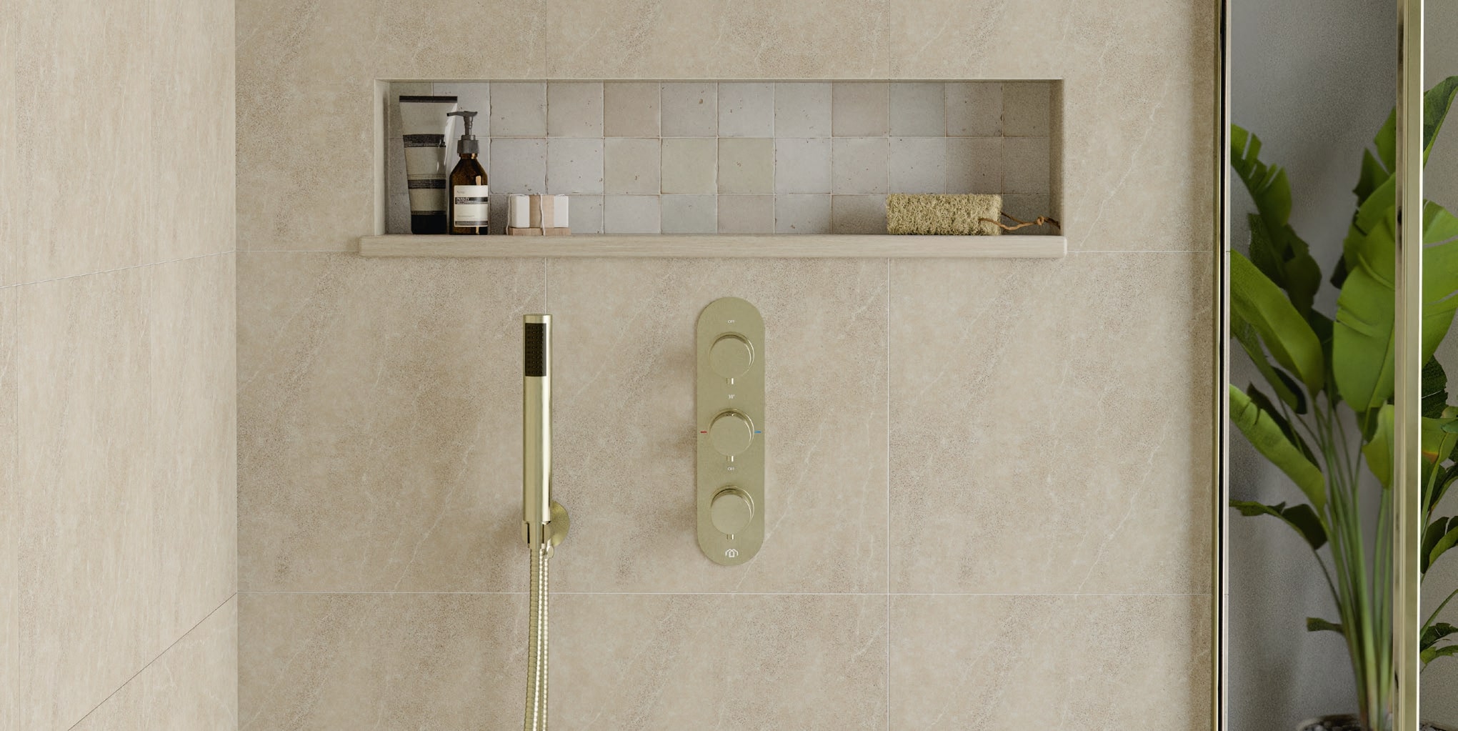 Beige tiled shower enclosure with a stylish recess for products - featuring a Maison Banos brushed brass shower head and valve set
