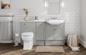 A New England inspired bathroom with light grey furniture, an integrated basin, toilet and natural accessories
